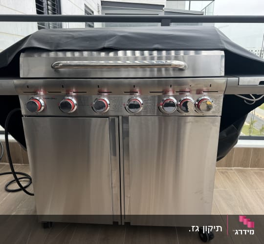 גריל נירוסטה עם שישה כפתורי שליטה ומכסה שחור